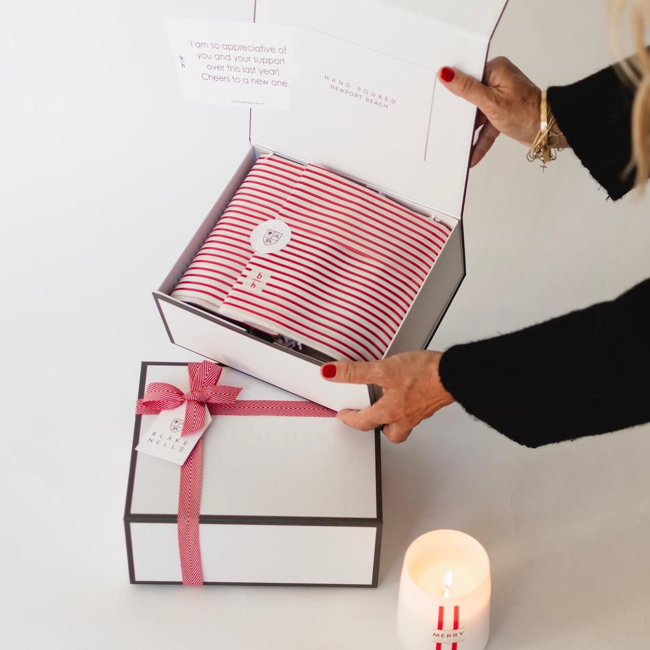 person holding corporate gift box open with tissue paper wrapping