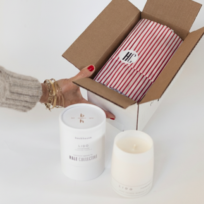 Open backhouse  box with striped red and white tissue paper, corporate gifting candle with custom cylinder box sticker