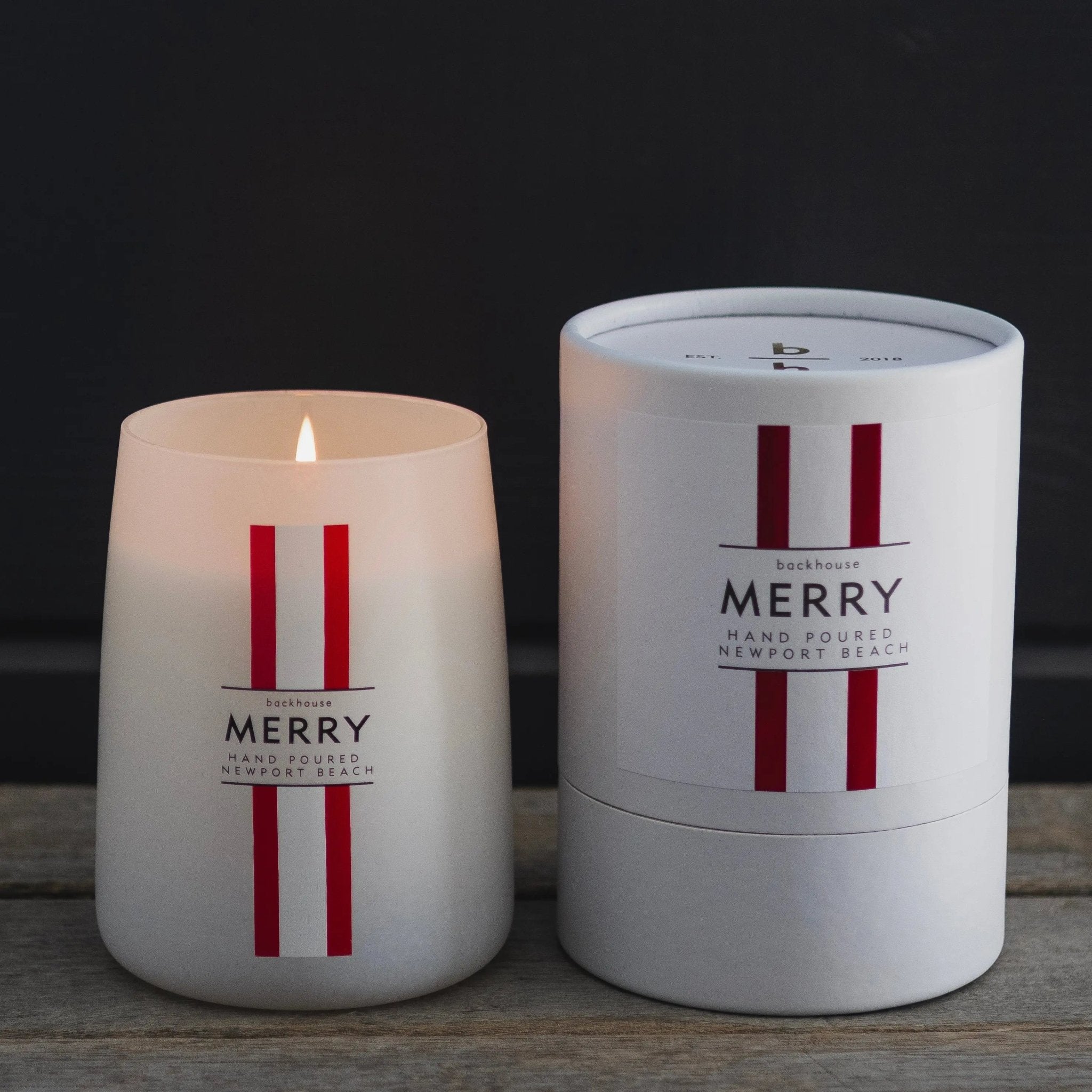 Merry Mr. Douglas pine candle by backhouse displayed beside its signature cylinder box against a dark background.