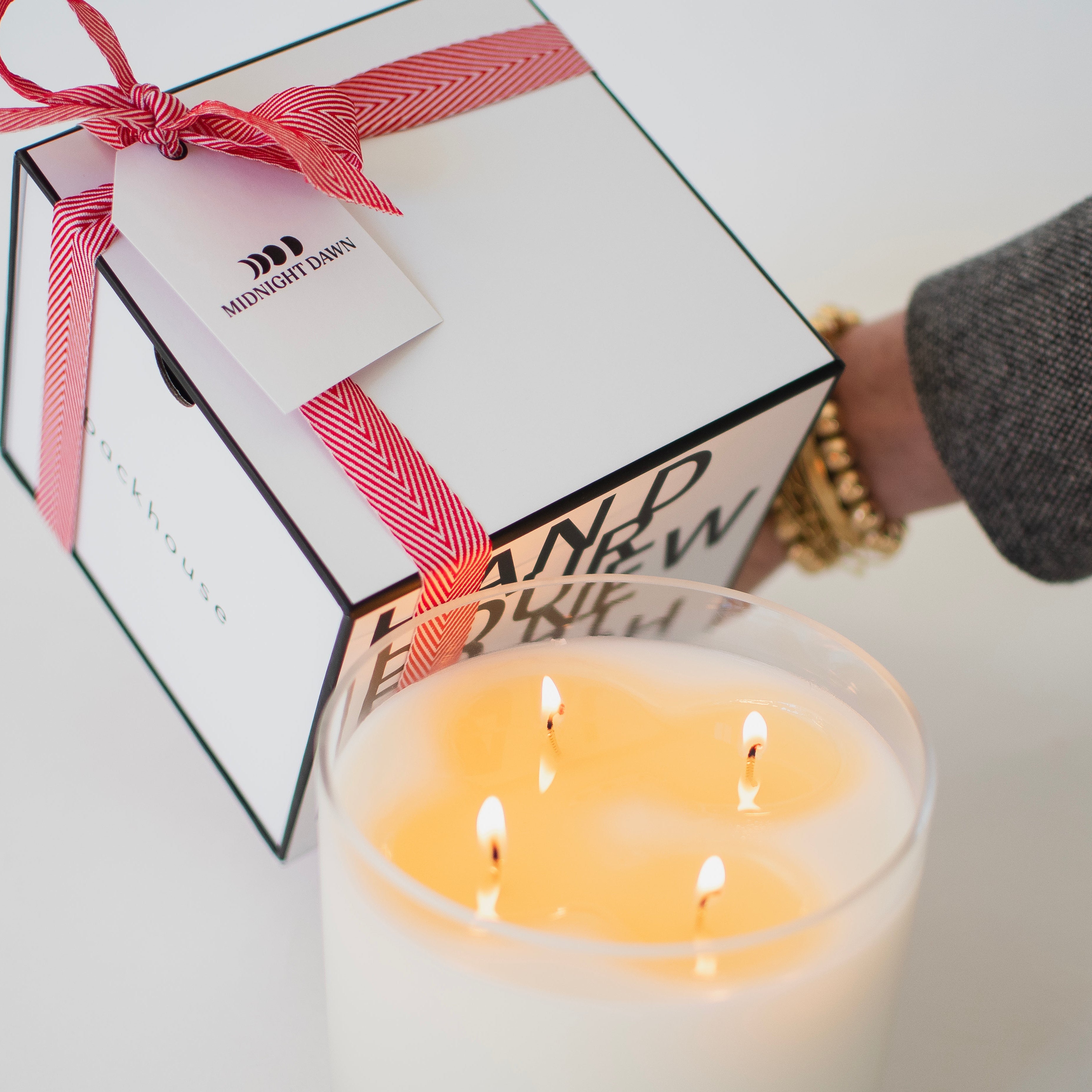 Candle with a gift box and red ribbon on a white background