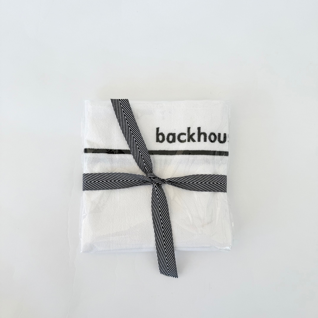 Classic dish towel by backhouse folded and wrapped with ribbon against a white background.