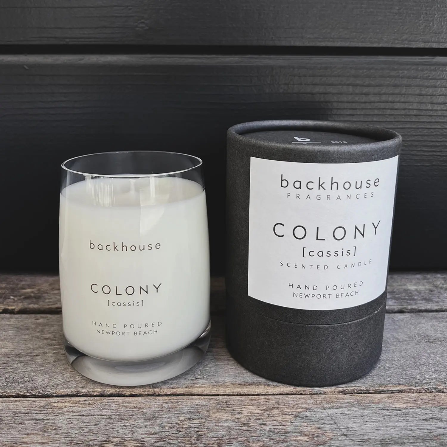 COLONY [cassis] candle with cylinder box on dark background. 