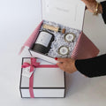 person holding corporate gift box showing contents inside 