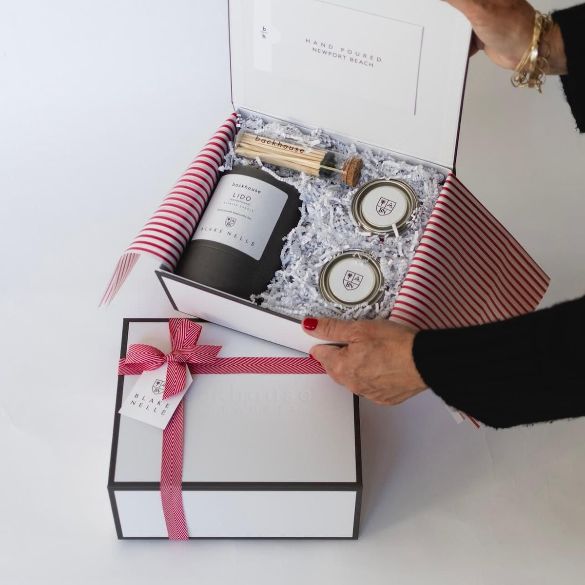 person holding corporate gift box showing contents inside 