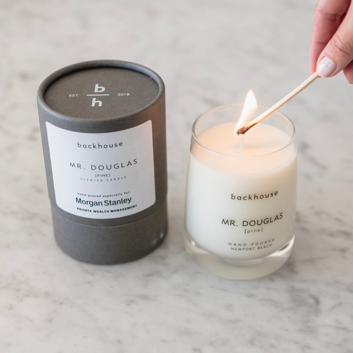 Backhouse Mr Douglas pine candle being lit with a match, hand poured corporate gift for Morgan Stanley Private Wealth Management