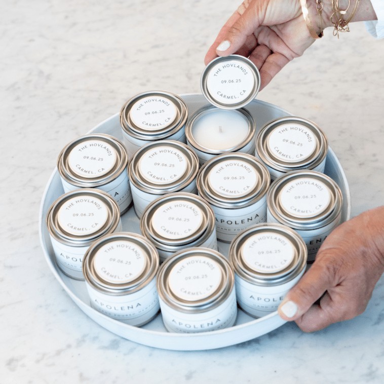 Custom mini wedding candles by backhouse featuring personalized lids arranged in a styled display.