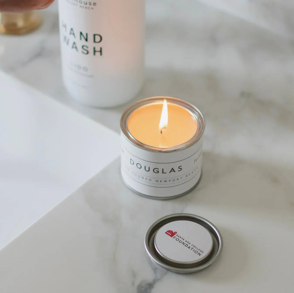 Corporate custom mini candle by backhouse Newport Beach burning near a bathroom sink.