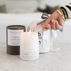 Lighting Backhouse Fragrances Lido sandalwood scented candle beside kraft gift packaging and branded gift bag, hand-poured luxury candle Newport Beach
