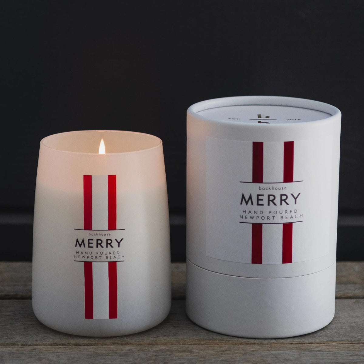 Merry Mr. Douglas pine candle by backhouse displayed beside its signature cylinder box against a dark background.
