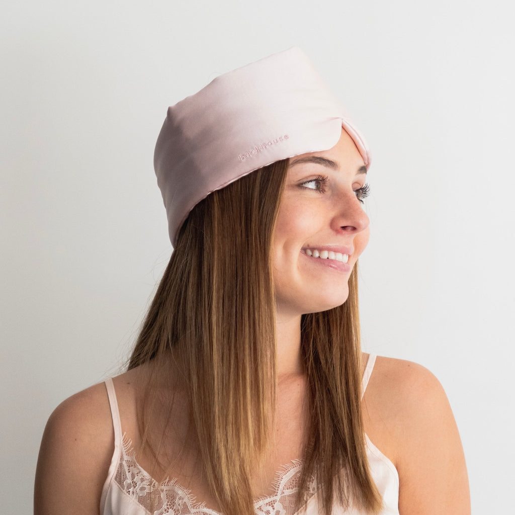 Woman wearing Backhouse blush pink silk eye mask — contoured blackout fit