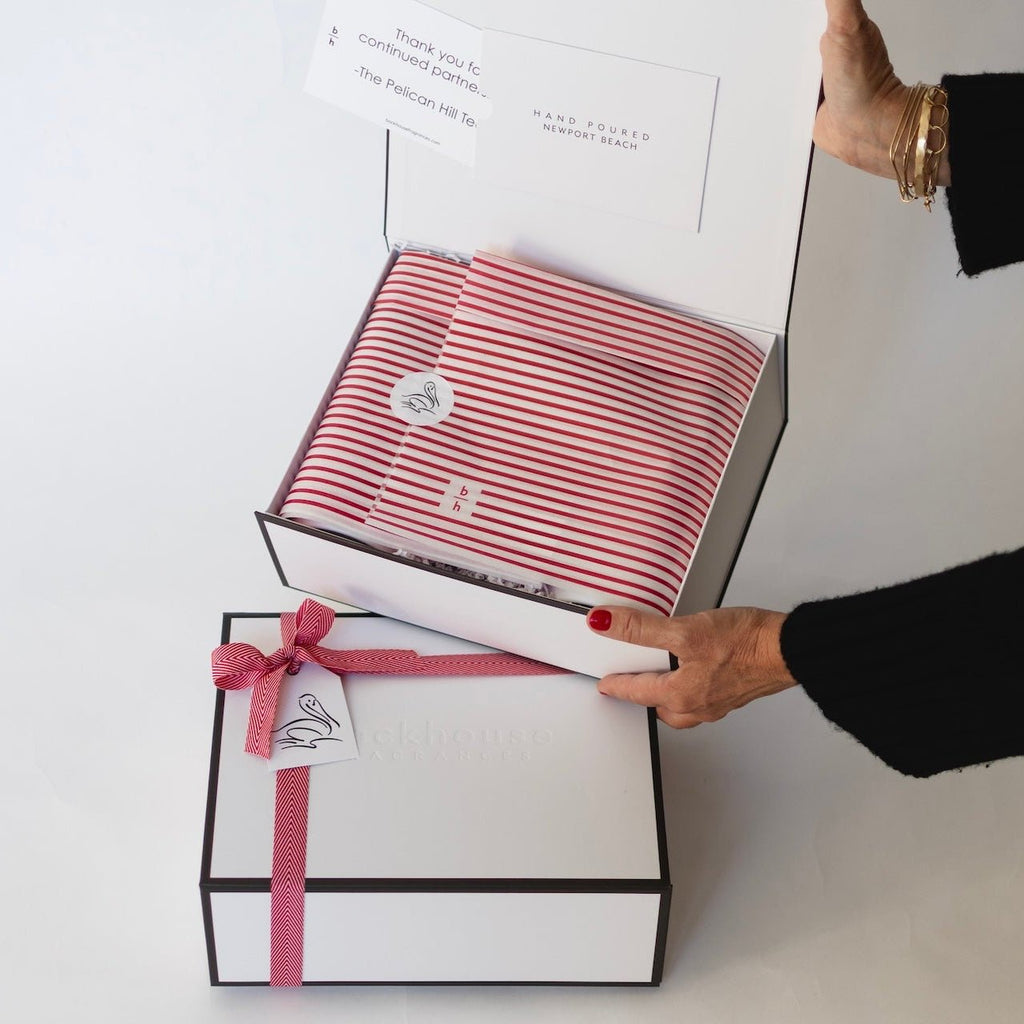 person holding corporate candle gift box showing wrapping and custom sticker backhouse fragrances