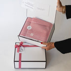 person holding corporate candle gift box showing wrapping and custom sticker backhouse fragrances