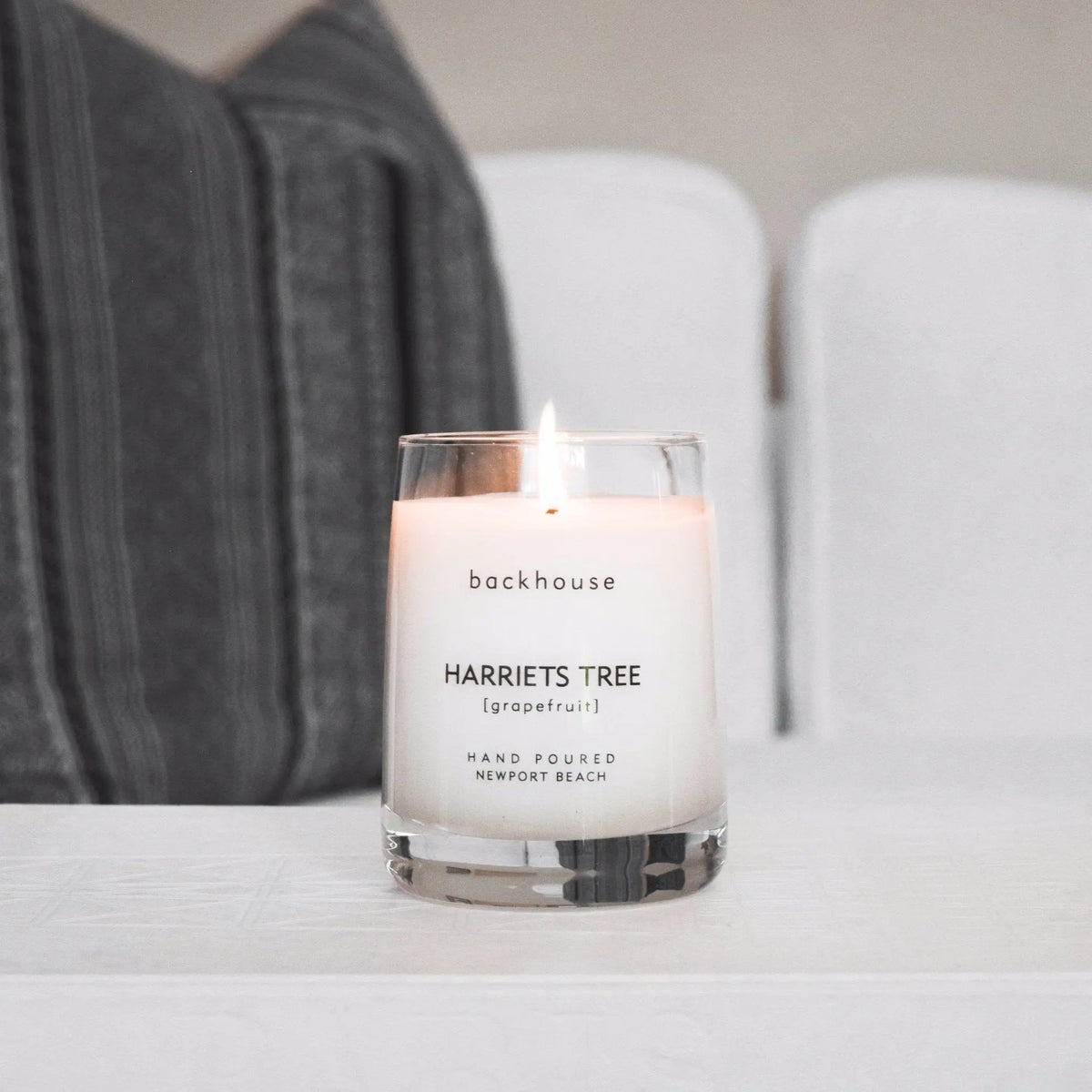 Harriets Tree grapefruit hurricane candle by backhouse burning on a coffee table. Newport Beach